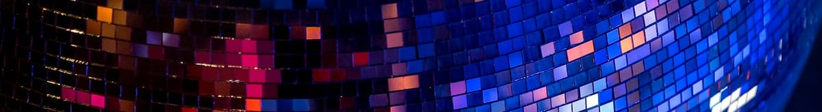 A mirrorball, reflecting hues of pink and blue and orange.