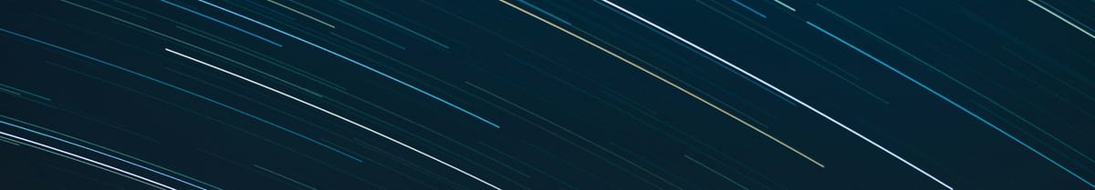 Streaks of light in a night sky, showing the motion of stars in a long-exposure photograph.